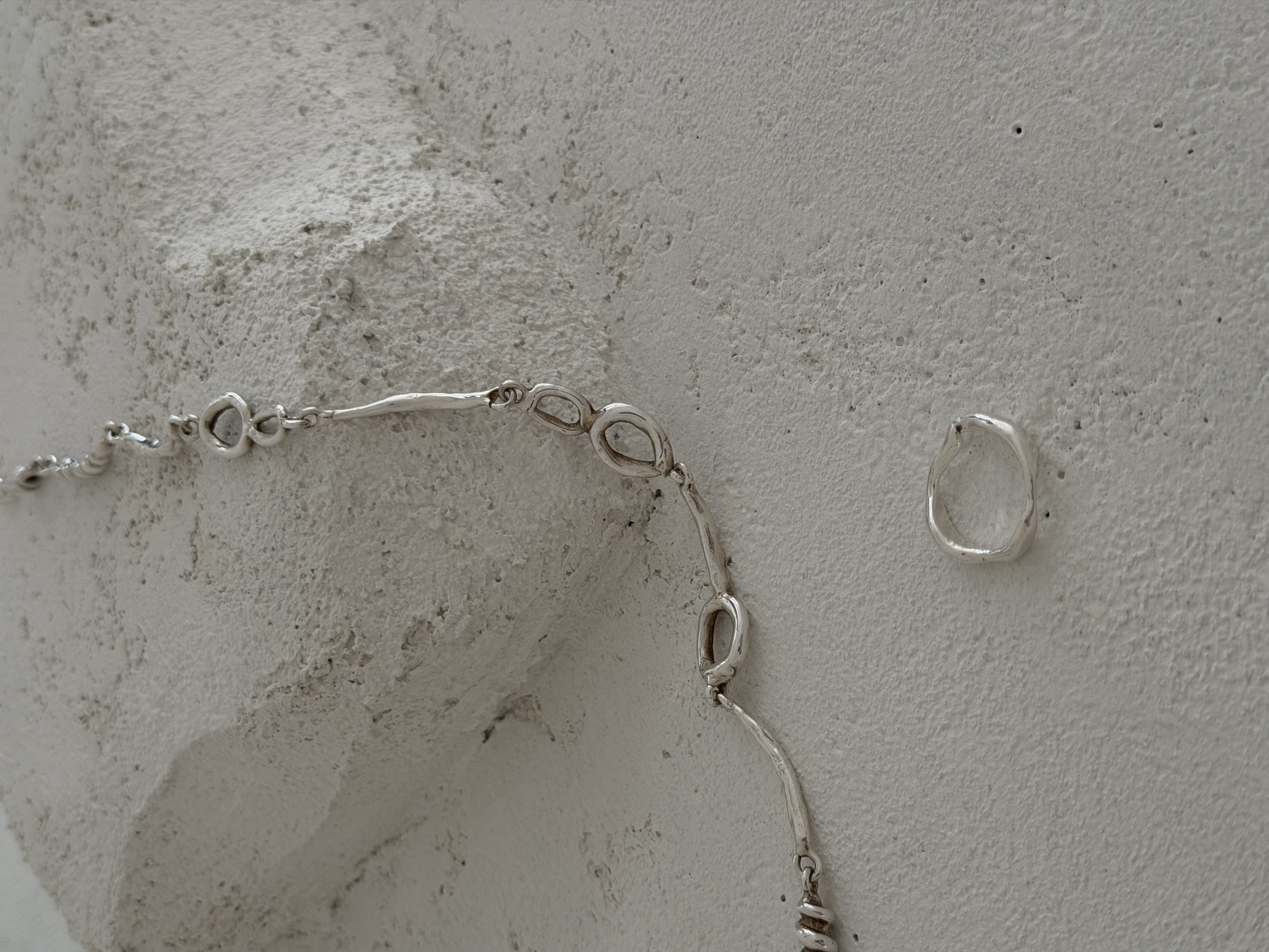 Silver necklace on concrete